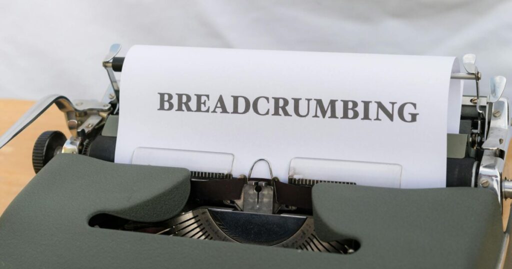 Close-up of a vintage typewriter with paper displaying the word 'BREADCRUMBING'.