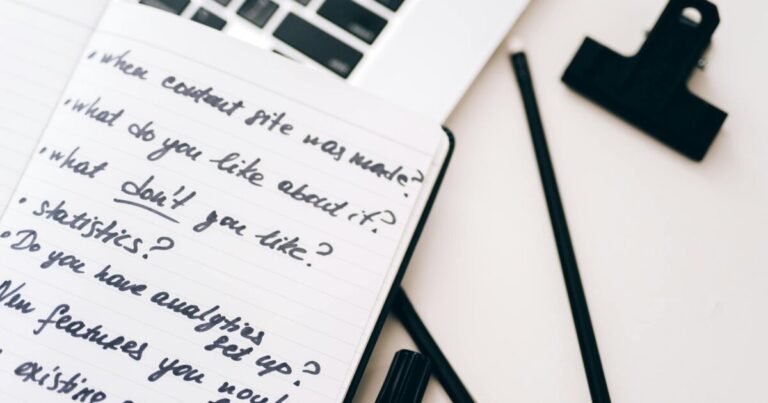 A close-up view of a notebook with handwritten notes alongside a laptop for planning and strategy.