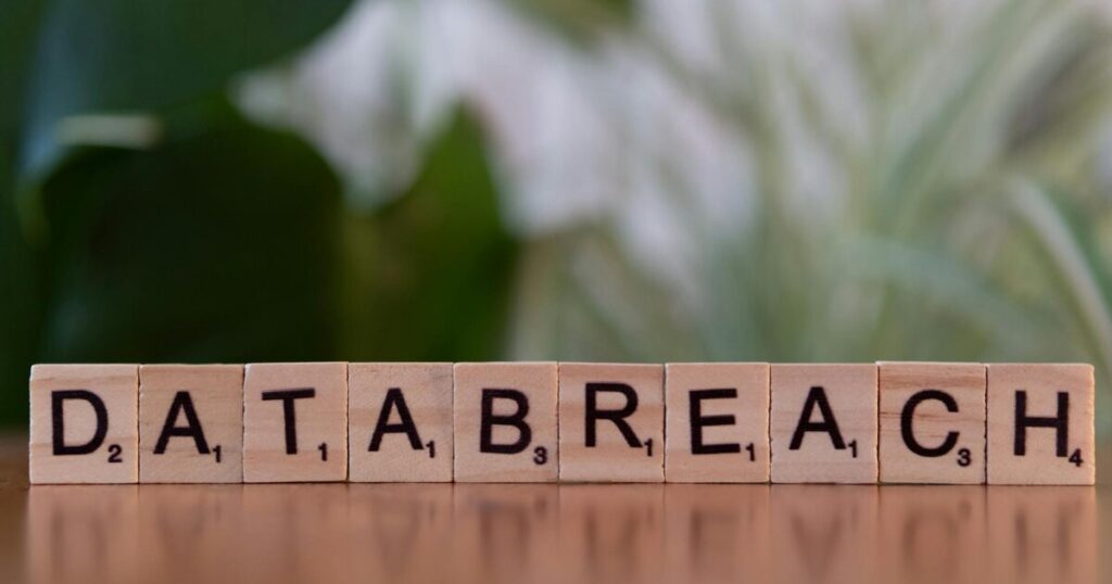 Close-up of Scrabble tiles spelling 'data breach' on a blurred background