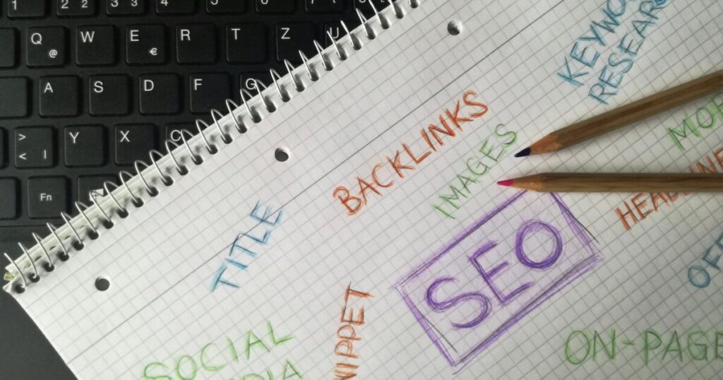 Close-up of notebook with SEO terms and keywords, highlighting digital marketing strategy.