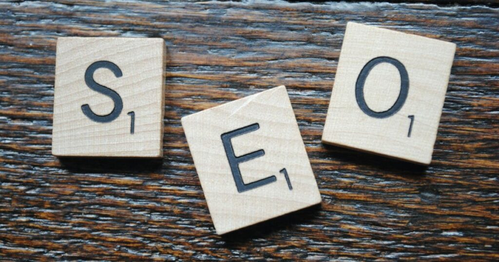 Close-up of Scrabble tiles spelling SEO on a wooden table for content strategy.