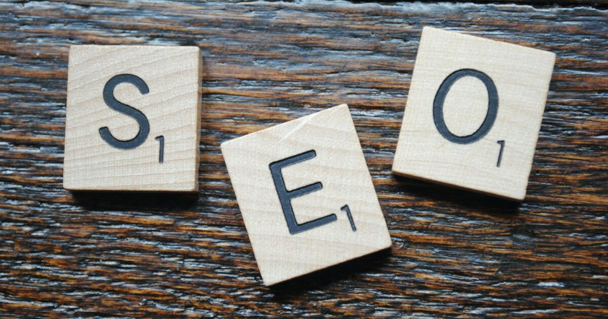 Close-up of Scrabble tiles spelling SEO on a wooden table for content strategy.