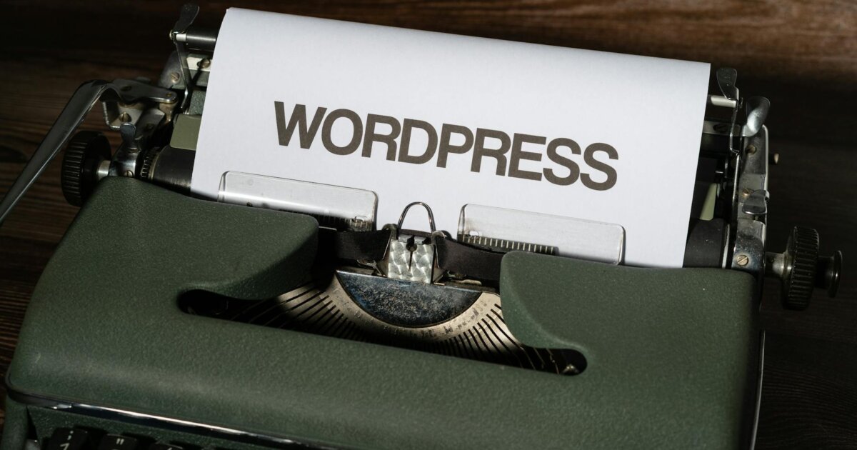 Close-up of a vintage typewriter with 'WordPress' typed on white paper.