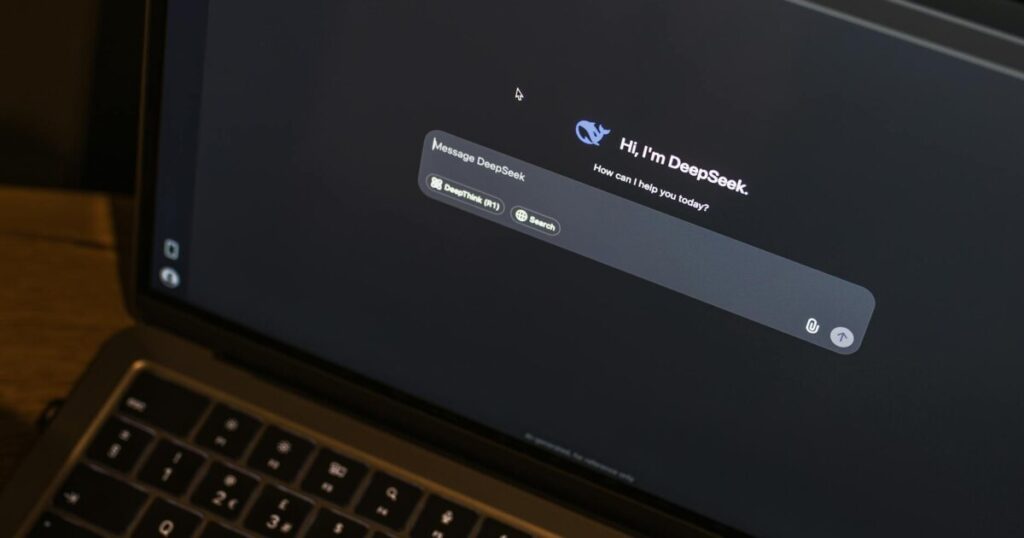 A laptop on a wooden table shows an AI chat interface, featuring the DeepSeek chatbot in action.