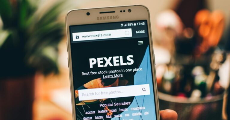 A close-up view of a smartphone displaying the Pexels website screen for stock photo searches.