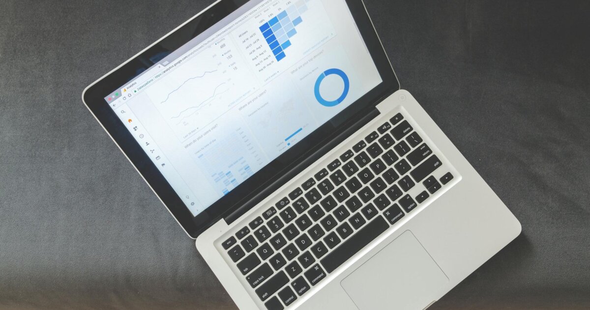 Overhead view of a laptop showing data visualizations and charts on its screen.