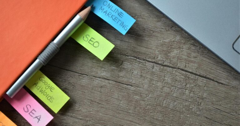 Close-up of SEO strategy planner with colorful sticky notes and a pencil on a notebook.