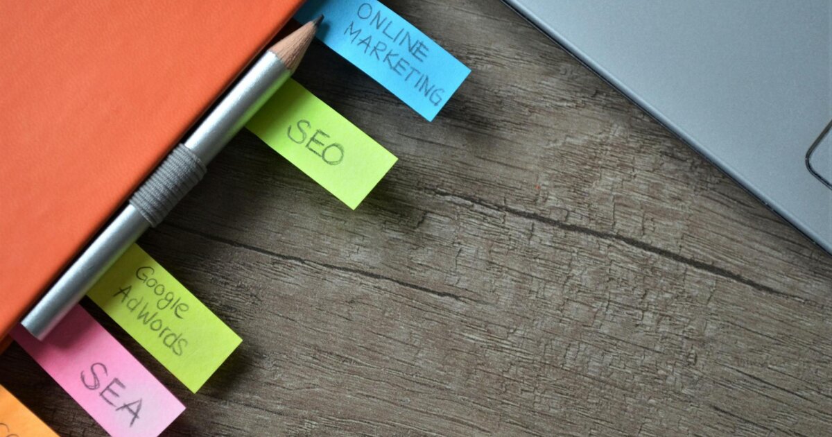 Close-up of SEO strategy planner with colorful sticky notes and a pencil on a notebook.